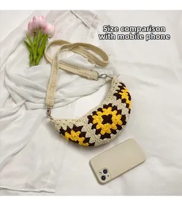 Detail of sunflower crochet crossbody bag showing size comparison with a smartphone