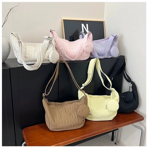Quilted crossbody bags in six colors with matching mini round pouches on a bench