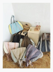 Detail view of large canvas tote bags in seven colorways with drawstring closure