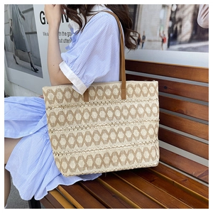 Large woven tote bag with brown oval patterns and leather handles for beach vacation
