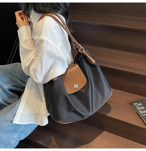 Classic color-block tote bag made of black nylon and brown leather on staircase