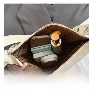 Détail de l'intérieur spacieux du sac à bandoulière crème avec poches de rangement