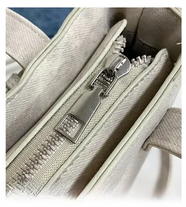 Detailaufnahme des glatten silbernen Metallreißverschlusses an dieser beigen Segeltuchtasche
