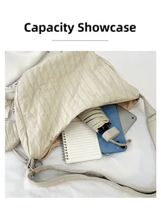 Detailed capacity display showing tablet, umbrella, and notebook in a cream crossbody bag