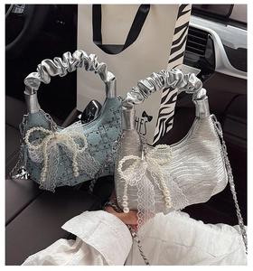 Detail of mini hobo bags with lace bows and pearl charms on a car seat