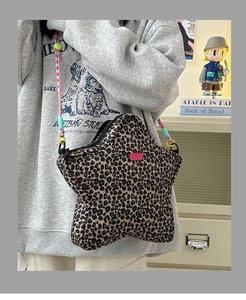 Detail of star-shaped leopard print crossbody bag with colorful woven shoulder strap