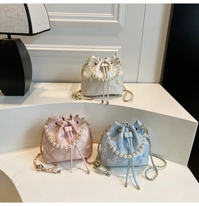 Three elegant lace bucket bags with pearl handles in white, pink, and light blue