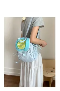 Detail of light blue backpack with lemon print and side drawstring on a model