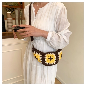 Detail of bohemian crochet crossbody bag with yellow sunflowe motifs on brown knit