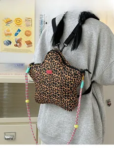 Detail of star-shaped leopard print crossbody bag with colorful woven rope shoulder strap