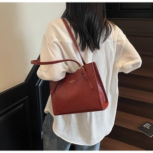 Detailed view of red retro leather tote bag with fine texture on wooden stairs