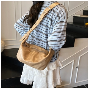 Détail du sac porté épaule en cuir camel avec bandoulière réglable et œillets en métal