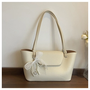 Detail of lychee pattern leather shoulder bag with lace bow and pearl heart charm
