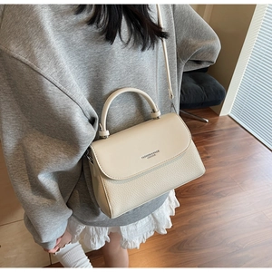 Detail of off-white lychee pattern leather shoulder bag with fashion lettering and flap