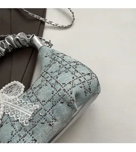 Detail of light blue denim handbag featuring rhinestone lattice and pearl lace edges