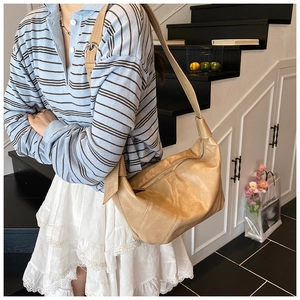 Sac bandoulière beige en demi-lune avec nœud latéral dans un style décontracté