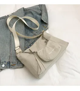 Detail of off-white canvas tote with pleated design and Happy Sunday pouch accessory
