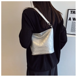 Detailansicht der silbernen Plissee-Beuteltasche mit Metallic-Struktur und Riemen