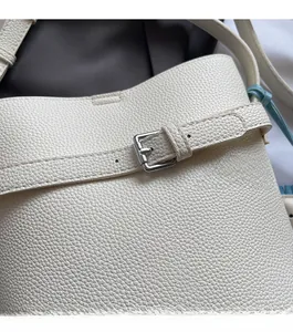 Detail of white lychee grain leather bucket bag with silver metal adjustable buckle