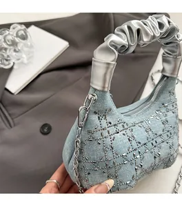 Detail of light blue denim handbag with silver rhinestones and ruffled handle