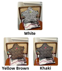 Three leopard print star bags in white, tan, and khaki on a vintage woven chair