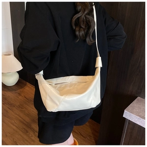 Détail du sac à bandoulière en similicuir beige minimaliste avec coutures et texture souple