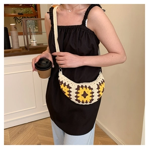 Detailed close-up of a handmade crochet sunflower crossbody bag with woven straps