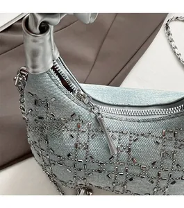 Detail of light blue denim handbag with silver rhinestones and smooth metal zipper