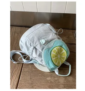 Detail of light blue drawstring backpack with a yellow lemon shaped front pocket