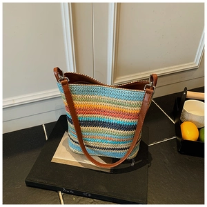 Macro shot of colorful woven texture and brown faux leather strap on bucket bag