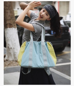 Outdoor shot of a large color-block tote bag in blue and yellow nylon for women