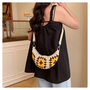 Detail of bohemian crochet crossbody bag with yellow sunflower patterns and knit texture