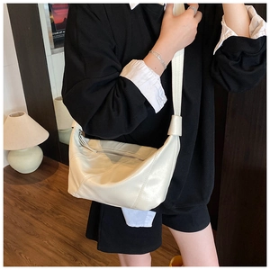Détail du sac à bandoulière en demi-lune blanc cassé en cuir PU avec fermeture éclair