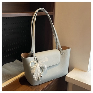 Close-up of light blue lychee pattern leather tote with pearl bow and heart charm