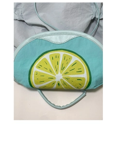 Detail of mint green crossbody bag featuring vibrant lime print and slim strap design