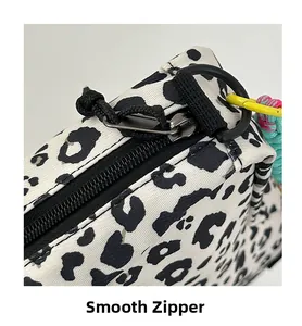 Detail of smooth black metal zipper with colorful braided strap on leopard print canvas bag