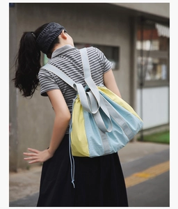 Detail of a drawstring backpack with yellow and blue color-blocking nylon fabric
