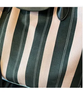 Macro shot of green and white vertical striped tote bag with cross-weave fabric texture