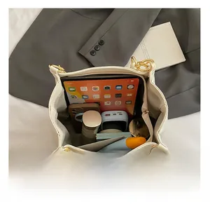 Intérieur du sac beige montrant la grande capacité pour tablette, téléphone et objets du quotidien