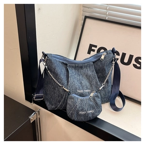 Detail of blue denim tote bag and mini pouch set with Happy Sunday white embroidery