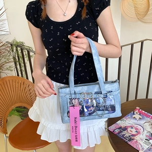 Detail der hellblauen Ita-Bag mit transparentem PVC-Fenster und silberner Herz-Kette