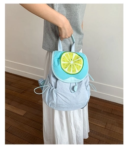 Detail of cute blue backpack featuring lemon print cover and side drawstring pockets