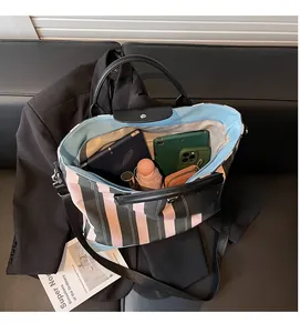 Detail of spacious striped tote bag interior showing capacity for tablet and daily items