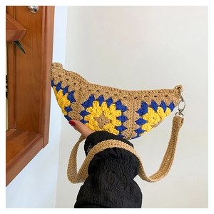 Detail of bohemian crochet half-moon bag with colorful sunflower patterns and woven strap
