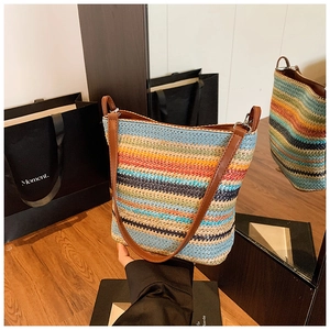Detail of colorful striped woven bucket bag with premium brown leather straps and metal buckle