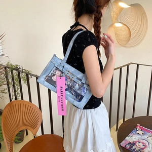 Detail der hellblauen Denim-Ita-Bag mit großem Klarsichtfenster und Herz-Kettenverzierung