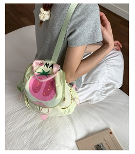 Girl wearing a yellow canvas backpack with a tomato print sitting on a white bed
