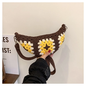 Detailed close-up of handmade crochet sunflower crossbody bag with woven wide strap