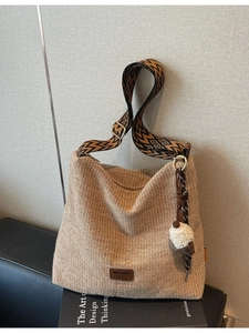 Handwoven straw tote bag with geometric strap and white pompom for summer beach trips