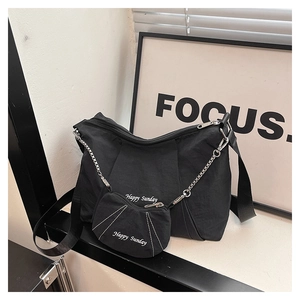 Close-up of black canvas hobo bag with Happy Sunday text and matching round coin purse